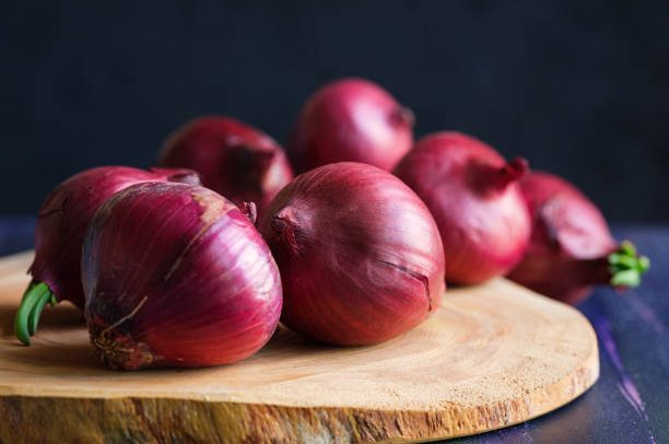 Red onions on wood board